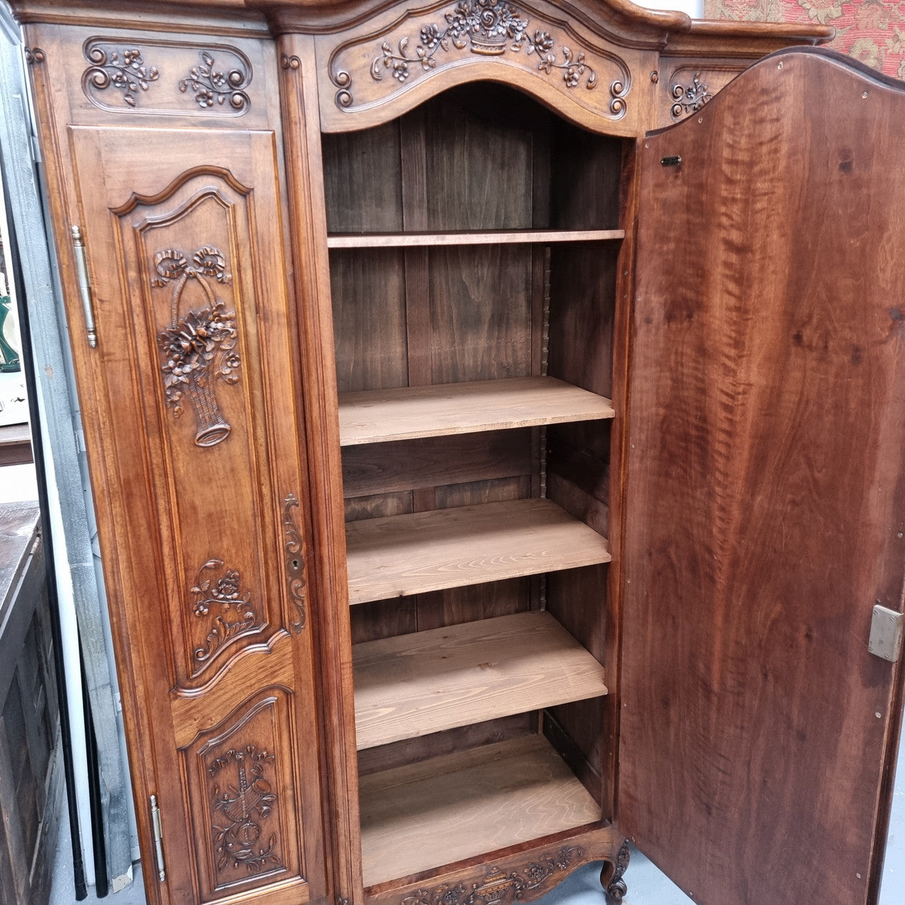 French Walnut Louis XV style three door armoire with 10 fully adjustable shelves in total spread over three sections, two drawers and a mirrored middle door. It has been sourced from France and in good original detailed condition.