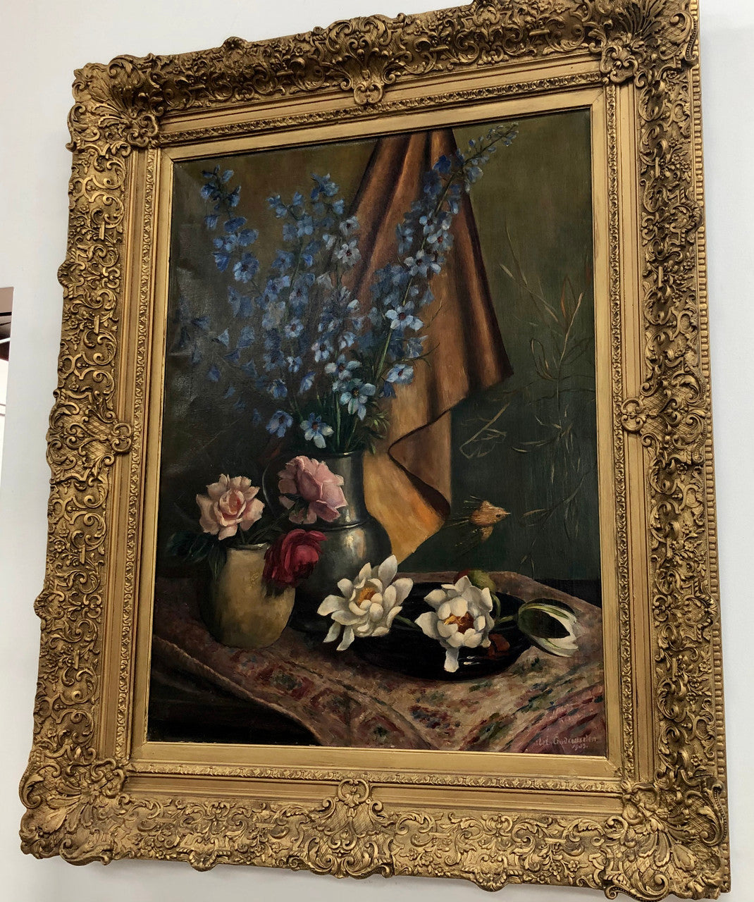 An Antique gilt-framed oil painting of floral still life. Housed in a double sweep gilt frame, signed and dated in good condition.