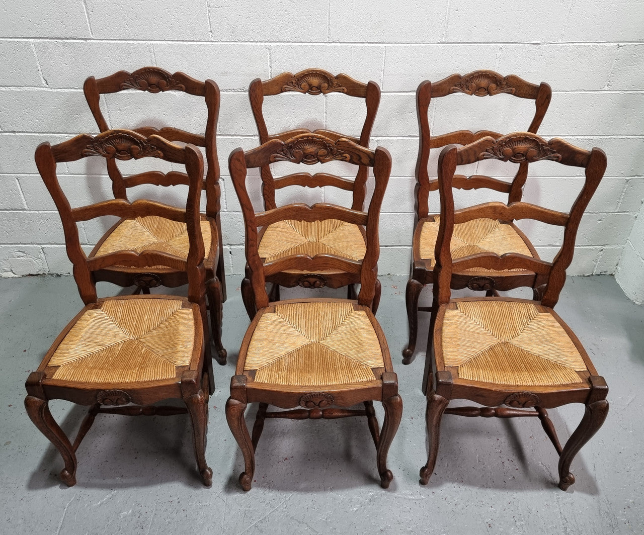 Lovely set of six French oak rush seated provincial dining chairs. They have been sourced from France and are in good detailed condition.