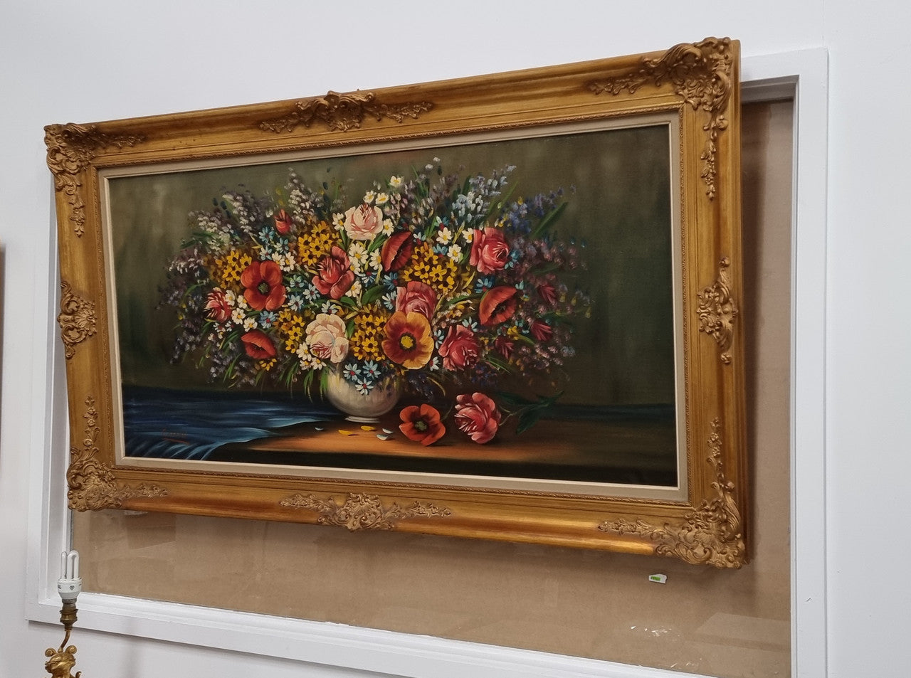 Sourced from France a stunning colorful floral oil painting on canvas. It is in a decorative gilt frame and is signed. It is in good original detailed condition.