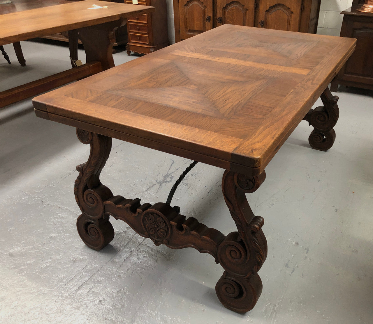 French Oak Renaissance style extension table with a lovely parquetry top and decorative carved and iron base in good original detailed condition.