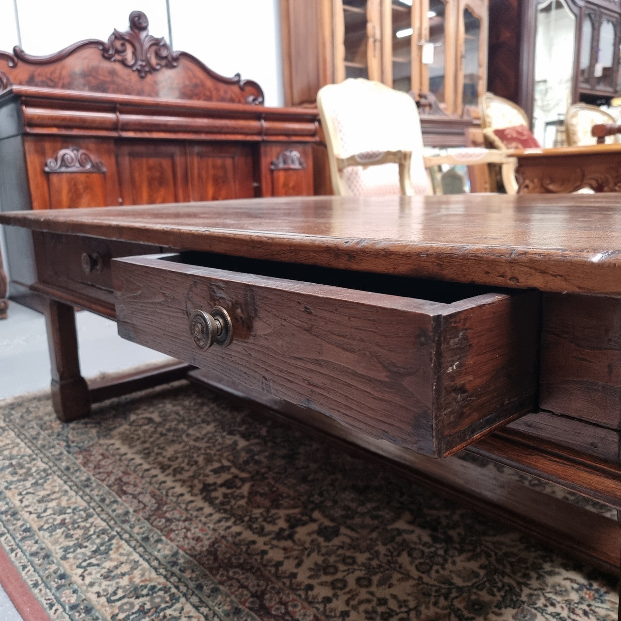 Impressive large size rustic French Oak coffee table with two drawers on a stretcher base. In good original detailed condition and sourced from France.