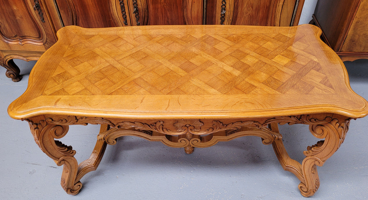 French Oak parquetry top coffee table with decorative carved base. It is in good original detailed condition.