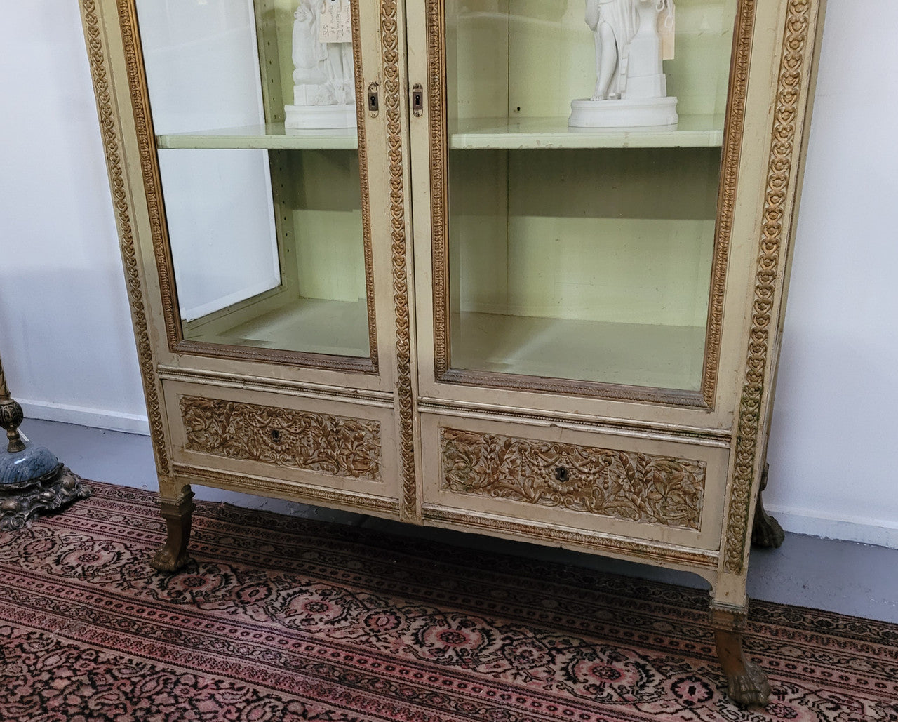 19th Century painted and gilt two door vitrine. Has one adjustable shelf and two drawers. In good original detailed condition.
