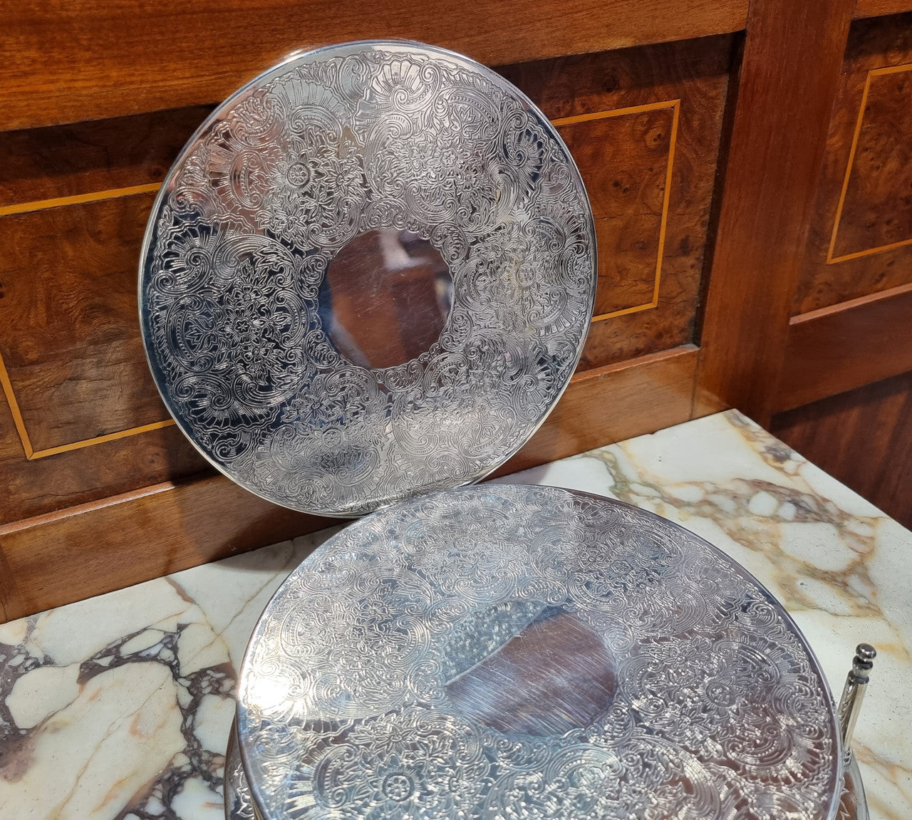 Five Strachan and two Rodd silver plate table coasters in a silver plate stand. In good original detailed condition.