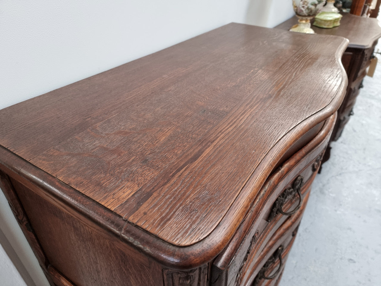 Antique French beautifully carved dark Oak commode with three drawers and ornate handles. It is in good original detailed condition.