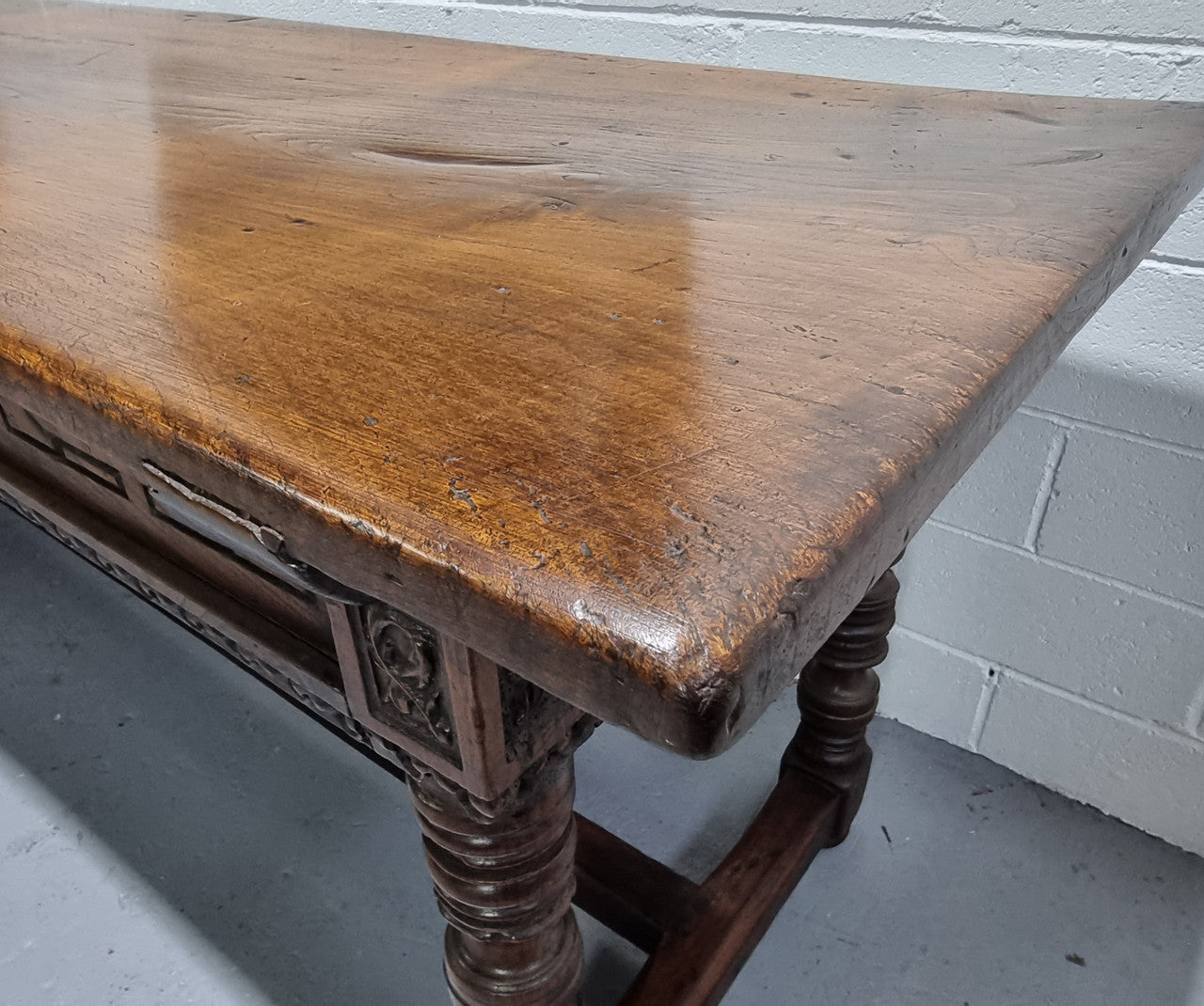 Rare and Charming 17th Century Spanish Walnut serving / side table. It has an incredible one piece walnut top with amazing character and colour. The base displays the original patina aswell as three drawers with carving and remnants of original locks. Superbly turned legs terminating on a stretcher base. Could be used as a large entrance console table, a side table or in a dining area as a serving table. In good original detailed condition especially considering its age.