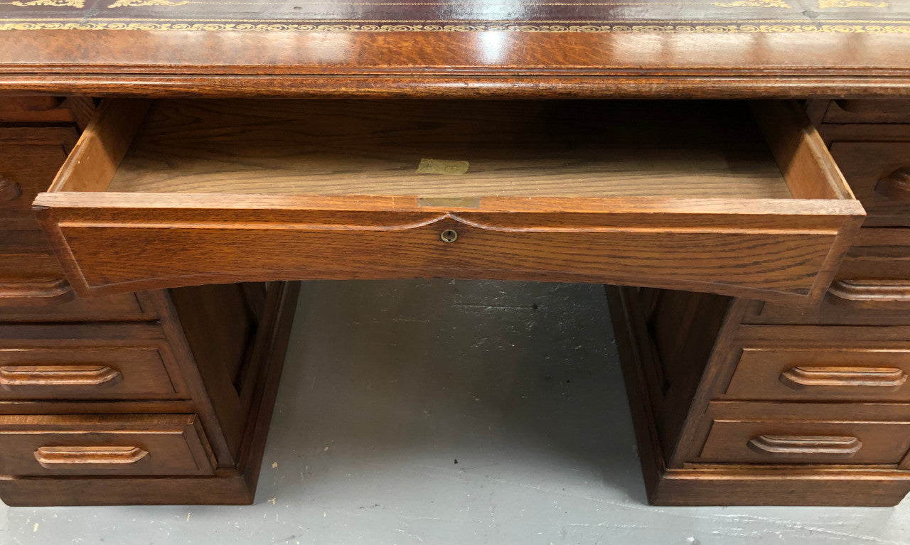 Lovely large English oak partners desk, with a beautiful burgundy tooled leather top. Plenty of storage space, both sides have 9 functioning drawers. It is in very good condition.