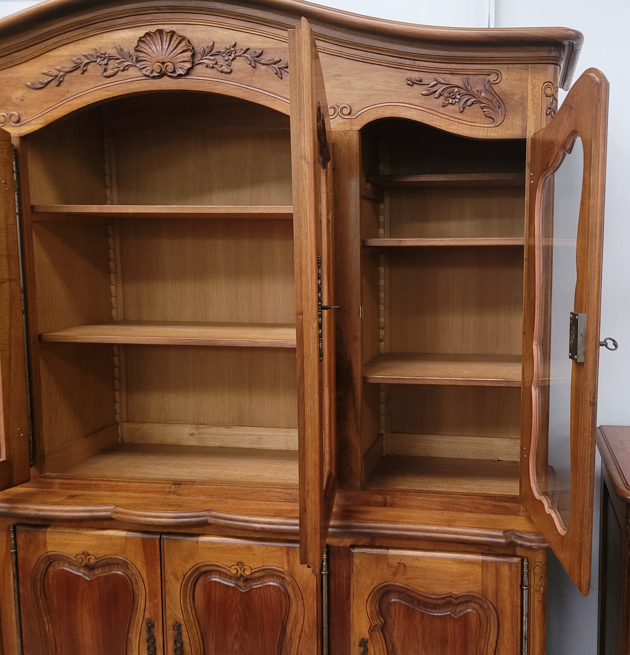 Magnificent French Walnut two-body four door display cabinet. Heaps of storage space with four glass doors at the top with shelves and four solid doors below also with shelving. It has been sourced from France and comes with a key for each door and all are lockable. In good original detailed condition.
