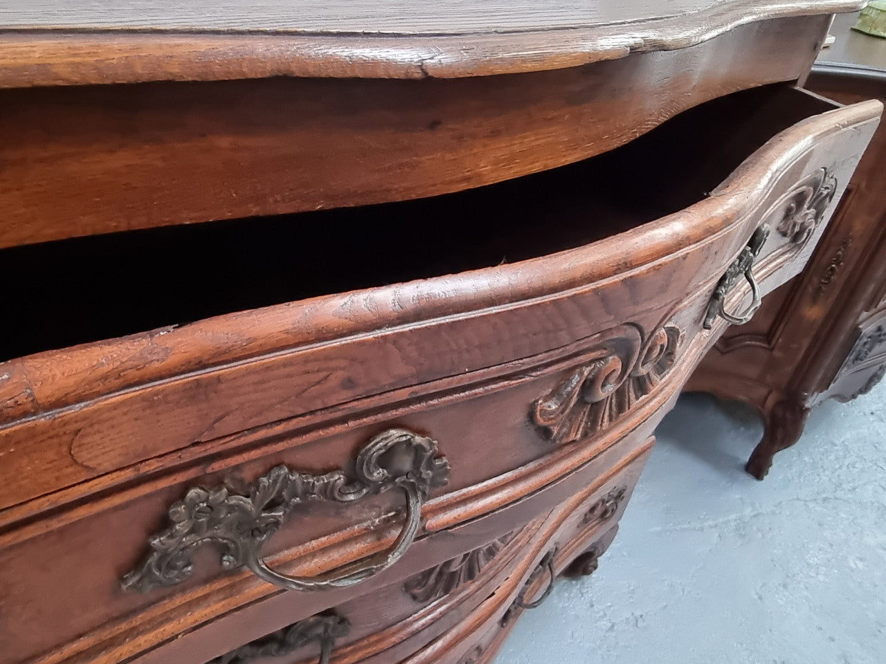 Antique French beautifully carved dark Oak commode with three drawers and ornate handles. It is in good original detailed condition.