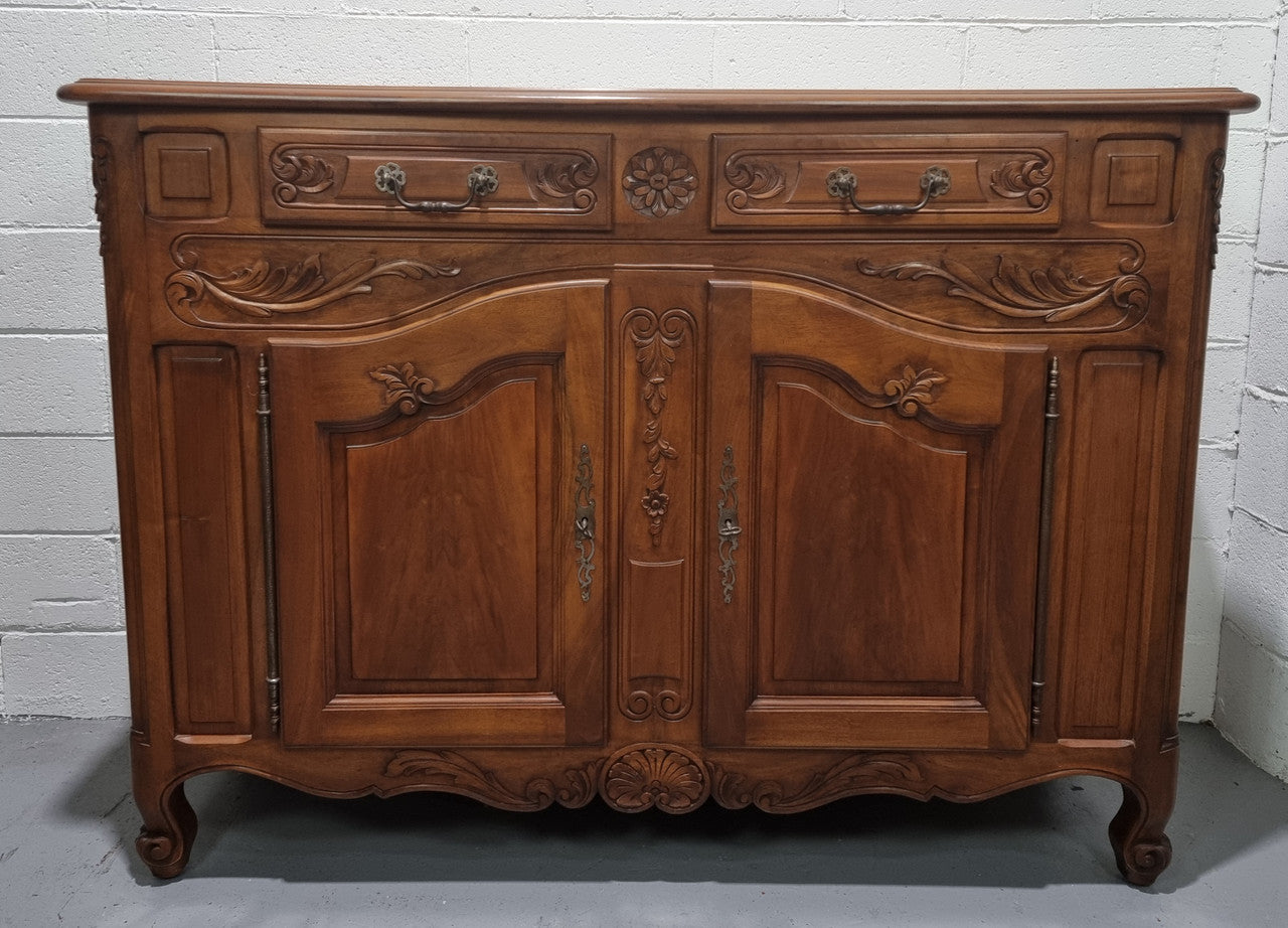 French Walnut two door buffet with parquetry top. It has two drawers and an adjustable shelf. In good original detailed condition and it has been sourced from France.