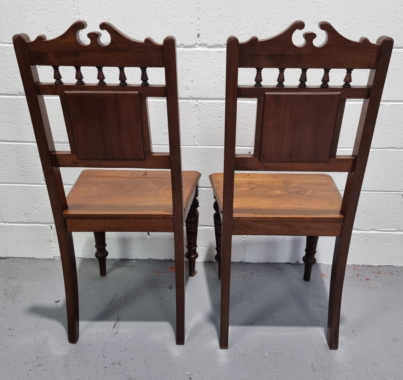 Pair of Edwardian Mahogany hall chairs with original tile in back. They are in very good original detailed condition.