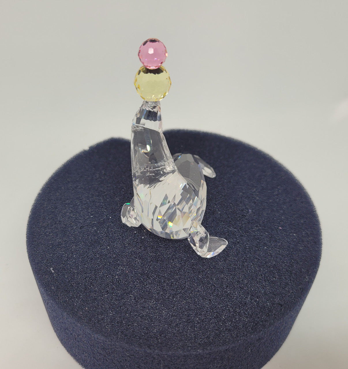 Swarovski crystal juggling seal. Jet eyes and balancing pink & yellow balls. Introduced 2003 and retired 2007. Comes with original box.