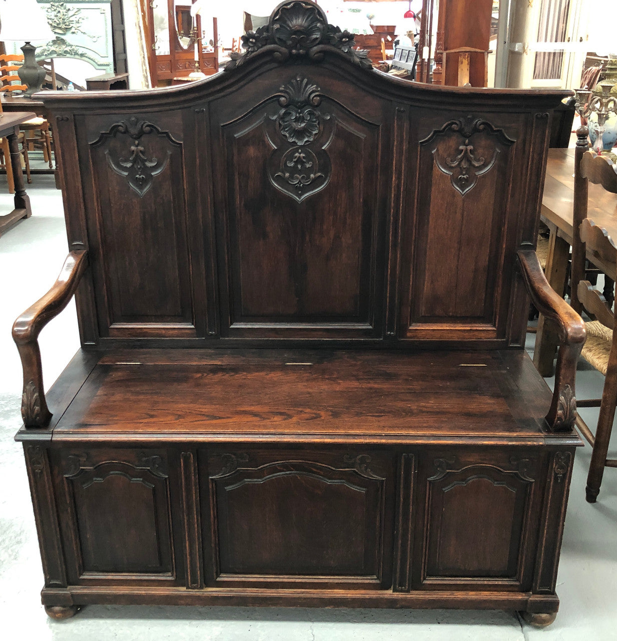 Beautifully carved French Oak hall seat with a lift up lid and storage space inside. In good original detailed condition.