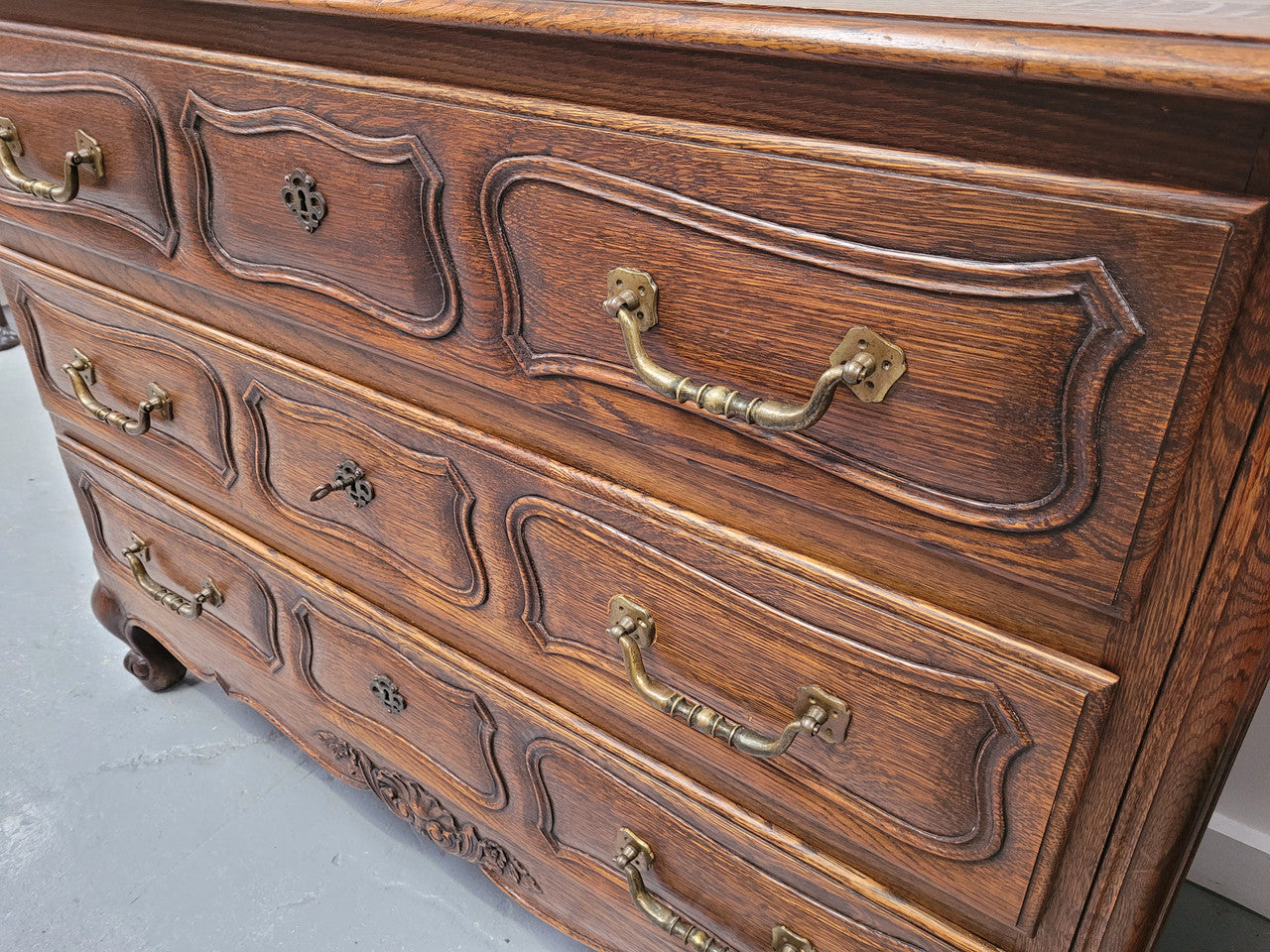 French Provincial Oak three drawer wooden top commode. It has elegant carvings and handles. It has been sourced from France and is in good original detailed condition.
