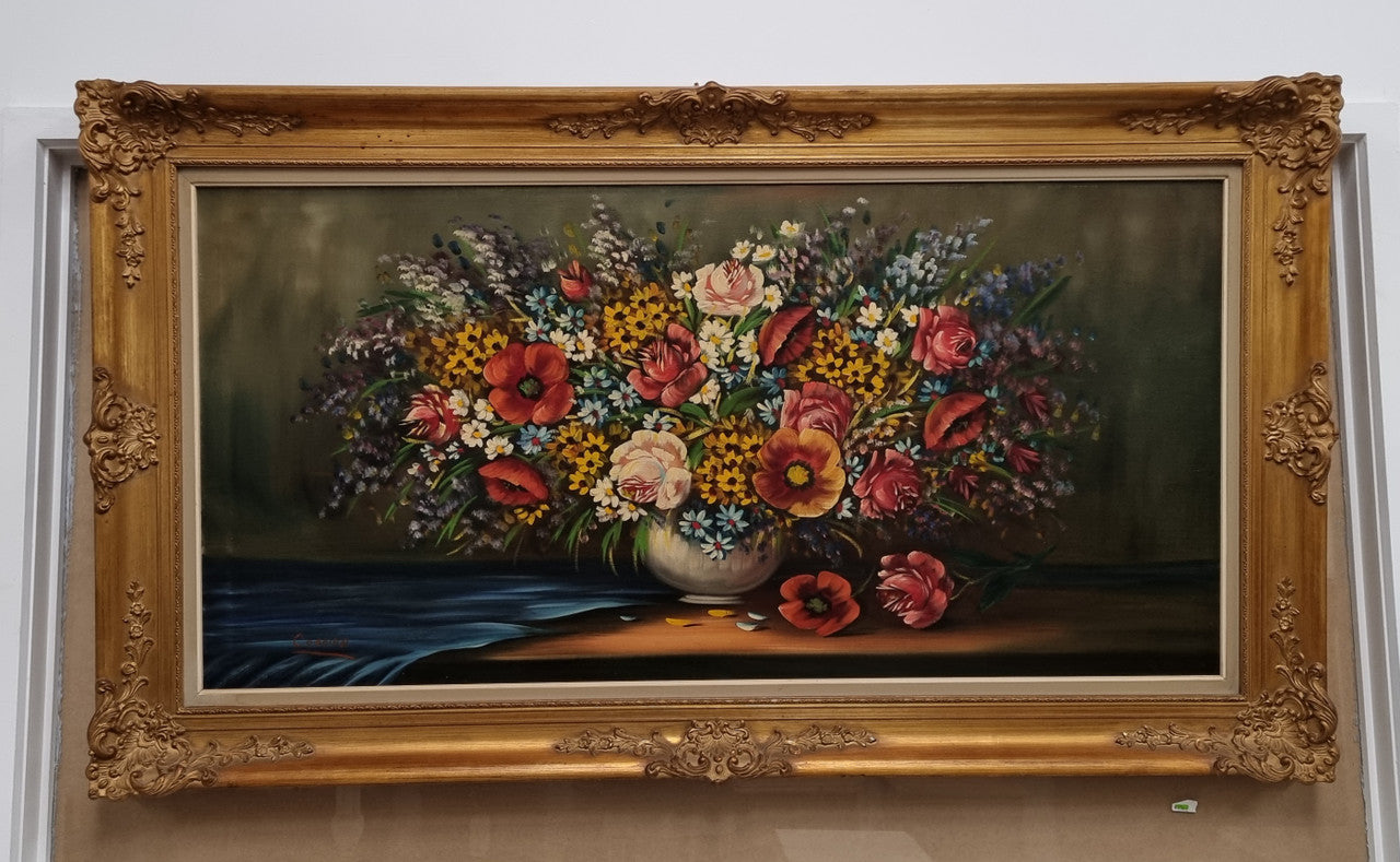 Sourced from France a stunning colorful floral oil painting on canvas. It is in a decorative gilt frame and is signed. It is in good original detailed condition.