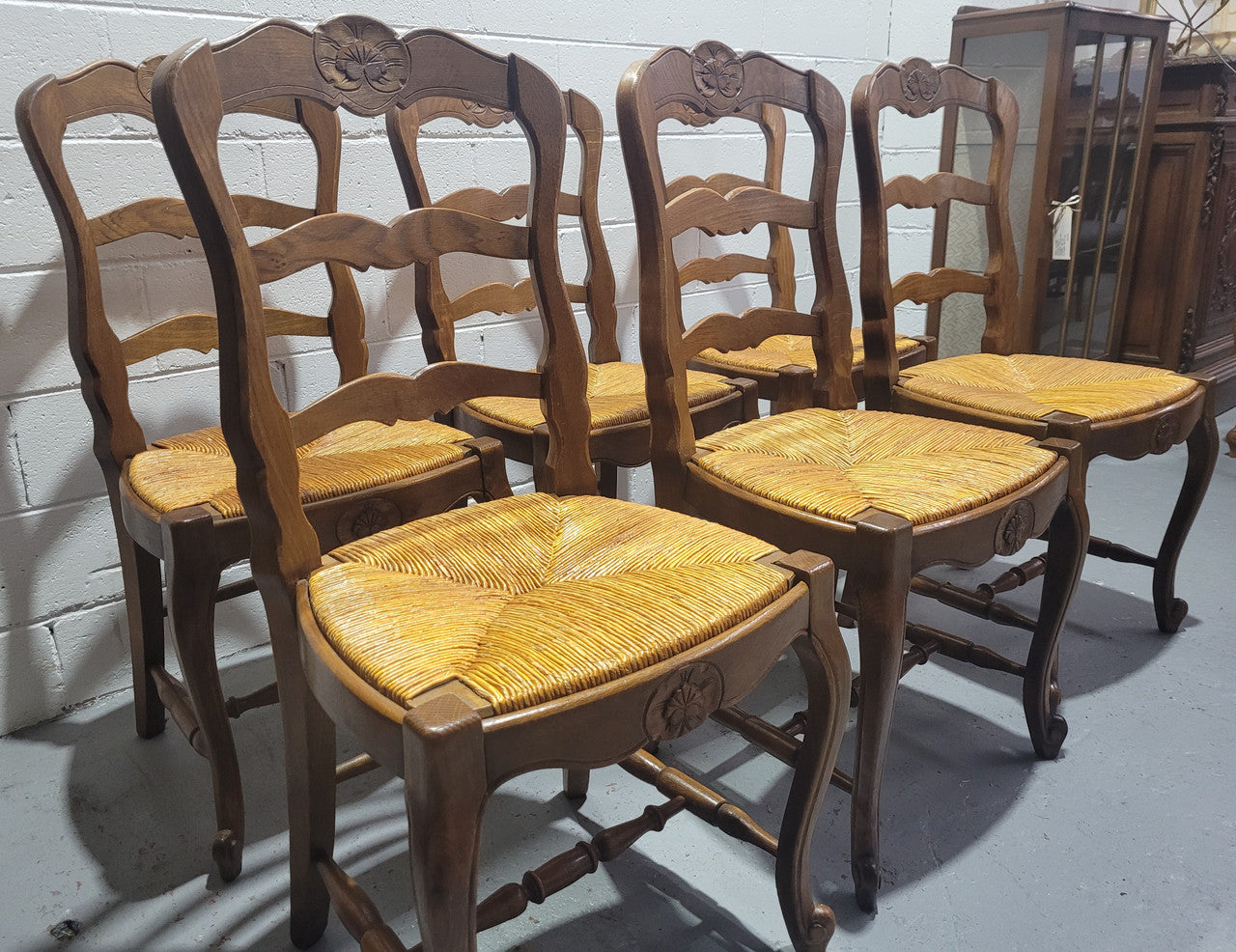 Set of six French Louis 15th style rush seated dining chairs. They are comfortable to sit in and are in original condition.