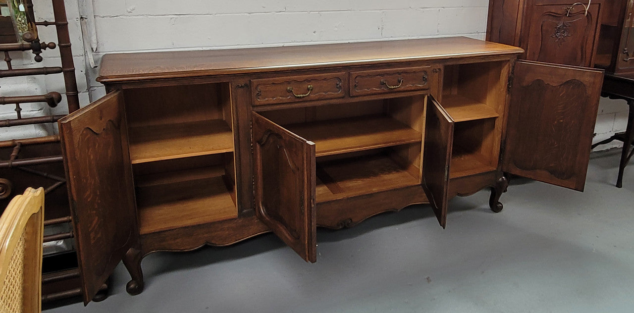 Louis XV style French Oak sideboard consisting of four doors and two drawers. It is in good restored condition.