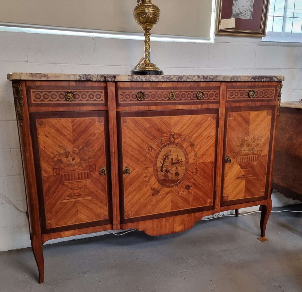 A high quality 19th Century French marquetry inlaid Kingwood marble top credenza. It has an attractive solid marble top and decorative marquetry inlay throughout. It has plenty of storage space with three drawers and three doors. It has been sourced from France and is in good original detailed condition.