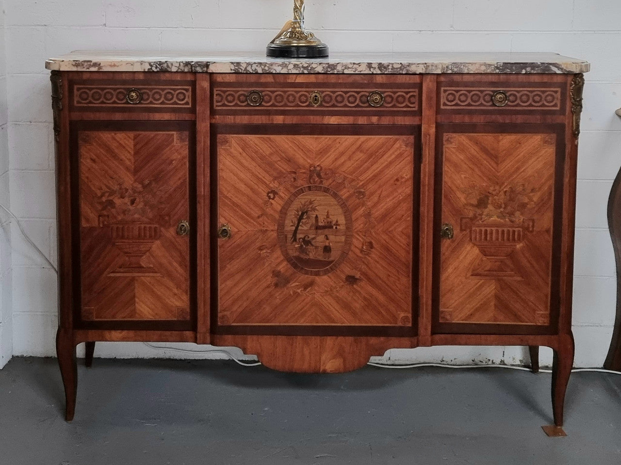 A high quality 19th Century French marquetry inlaid Kingwood marble top credenza. It has an attractive solid marble top and decorative marquetry inlay throughout. It has plenty of storage space with three drawers and three doors. It has been sourced from France and is in good original detailed condition.
