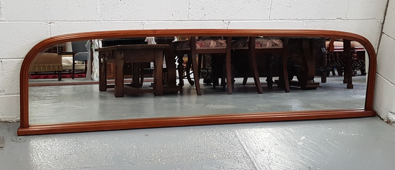 Art Deco mahogany mirror of long and narrow portions. In good original condition and retaining it's original mirror.