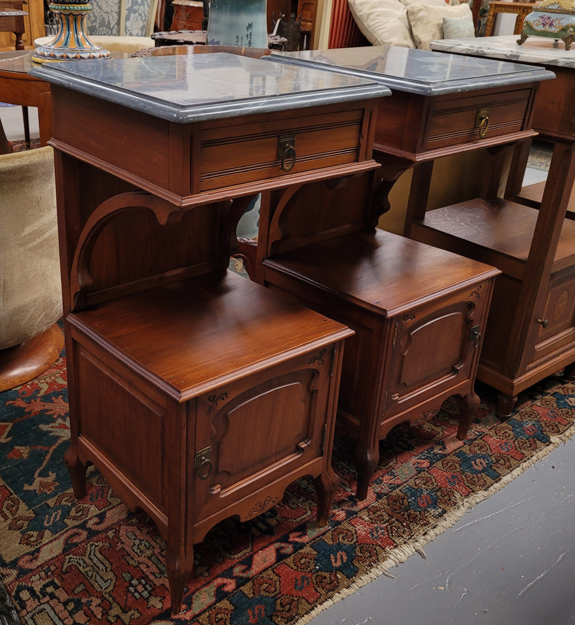 Pair of unusual transitional fruit wood marble top bedside cabinets. They have been sourced from France and are in good original detailed condition.