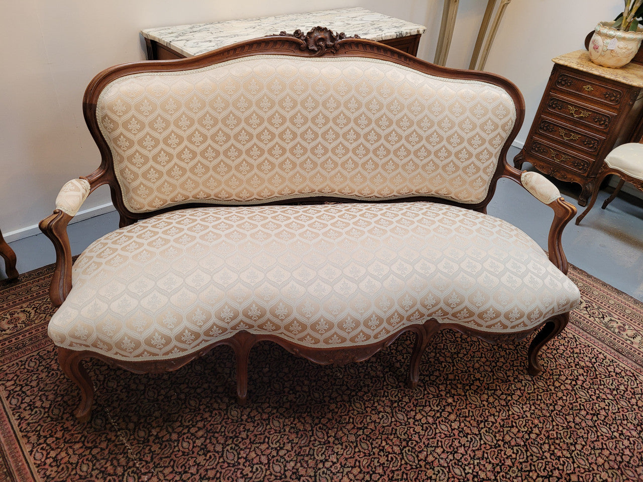 A late 19th Century French Walnut Louis XV style settee with a serpentine front. This settee upholstery is like new and is in very good condition.