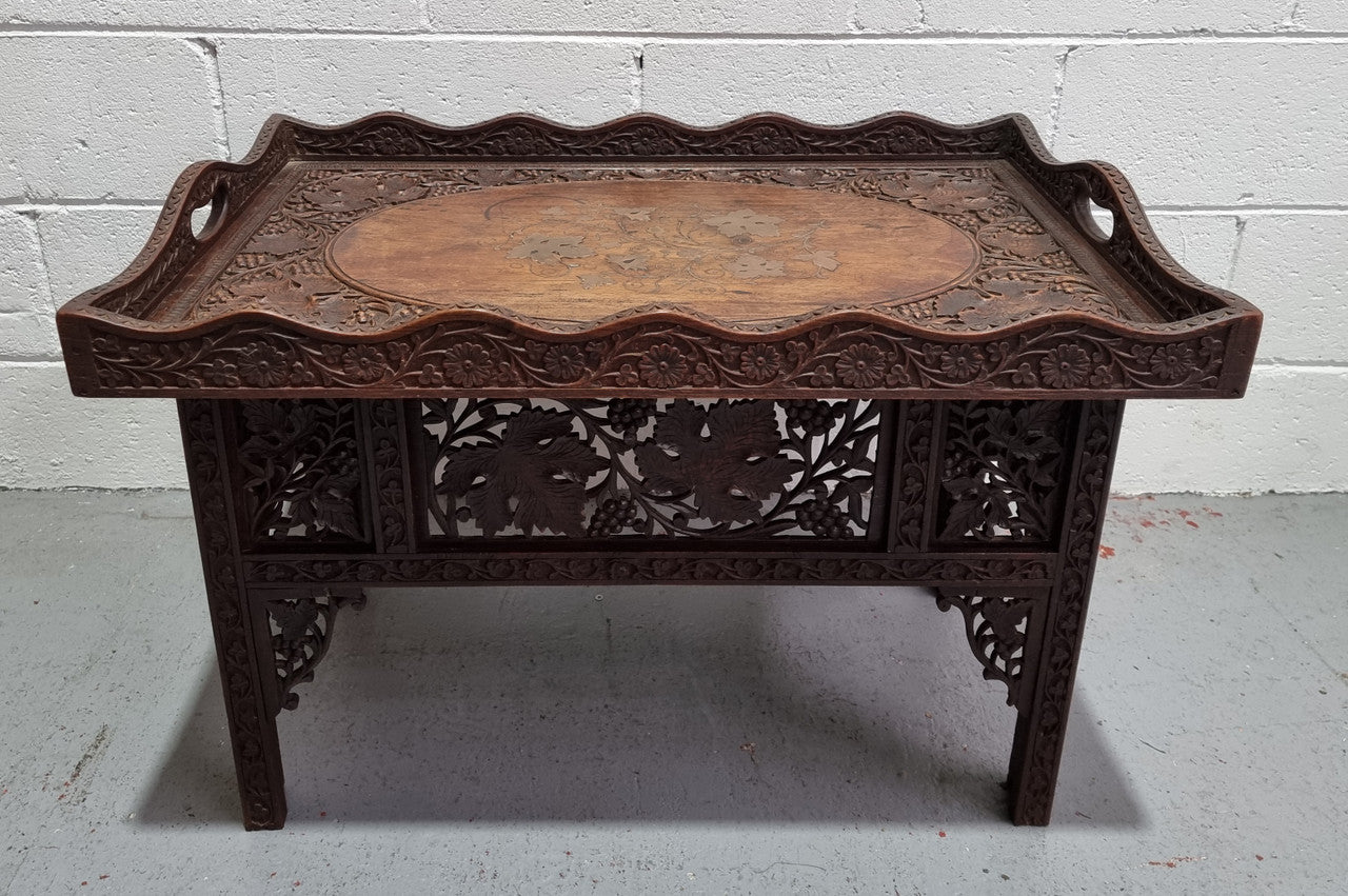 Anglo Indian folding occasional table with lift-up tray top. The tray has brass inlay and ornate carvings. The bottom of the table folds down and it is in good original condition.
