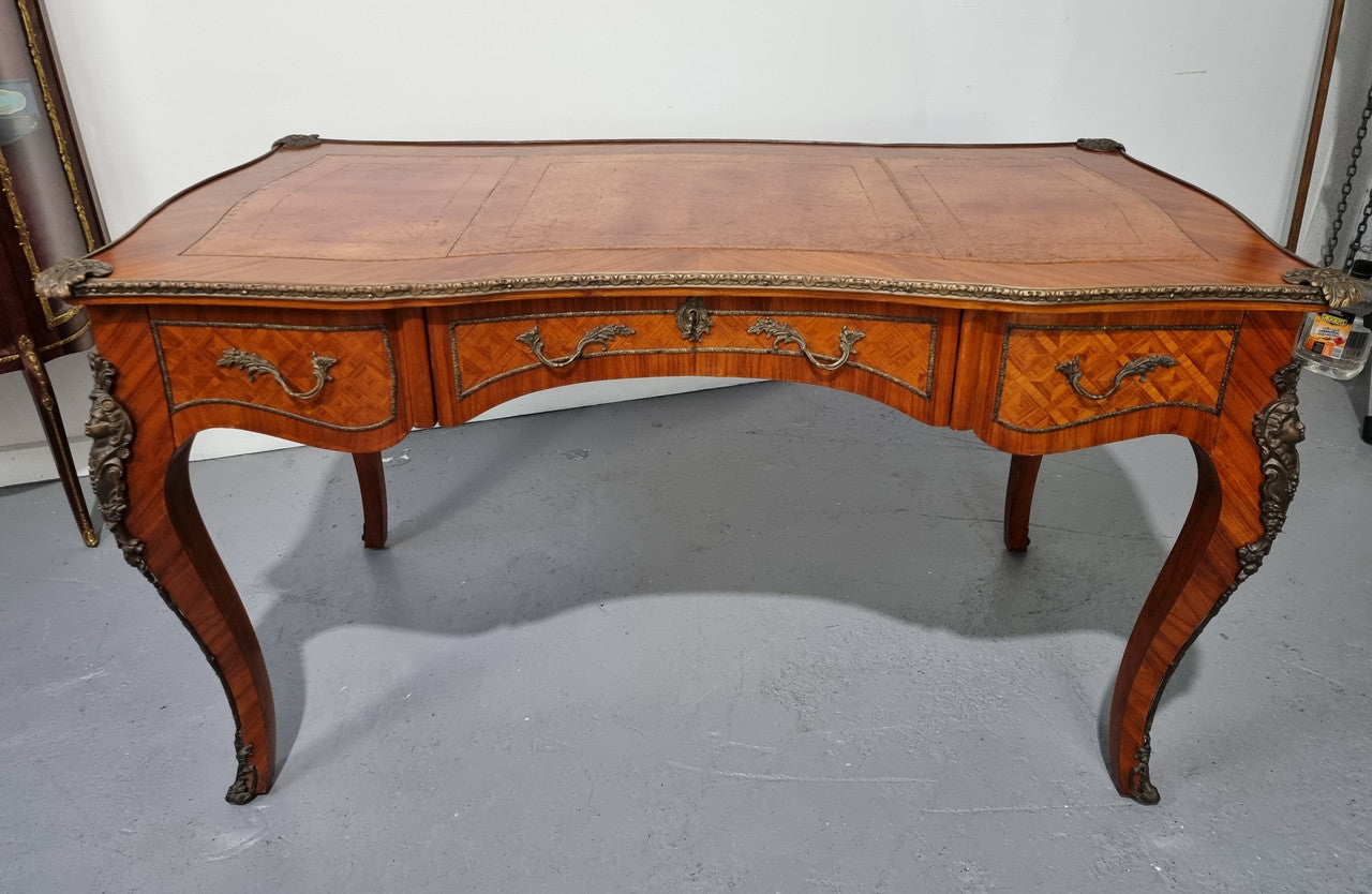 An impressive French kingwood and ormolu mounted bureau plat. It has a brown tooled leather writing surface, three decorated frieze drawers to the shaped apron with foliate swing handles and well cast figural mounts. Beautiful cabriole legs with decorative ormolu mounts and trims throughout. In good original detailed condition.