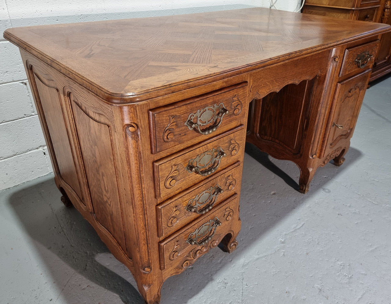Beautifully carved french oak, faux partners desk with a lovely parquetry top and 6 drawers and 1 cupboard . In good original condition.
