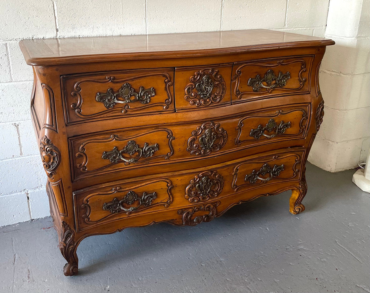 French Walnut Louis XV style five drawer commode. It has a beautiful wooden top and is beautifully carved. It is in good original detailed condition.