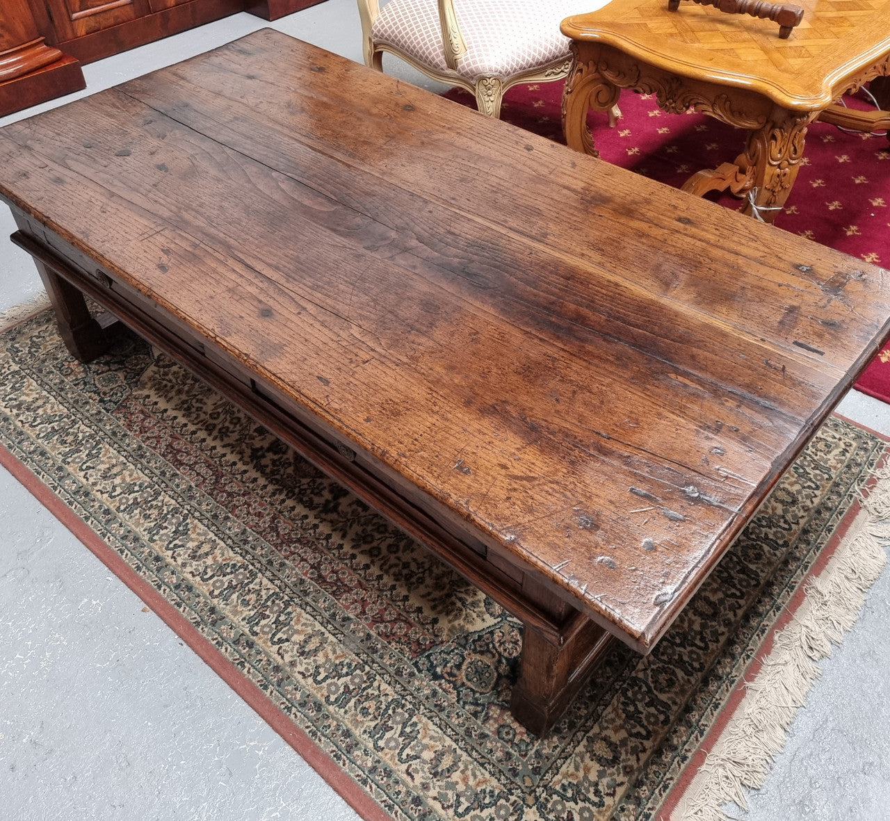 Impressive large size rustic French Oak coffee table with two drawers on a stretcher base. In good original detailed condition and sourced from France.