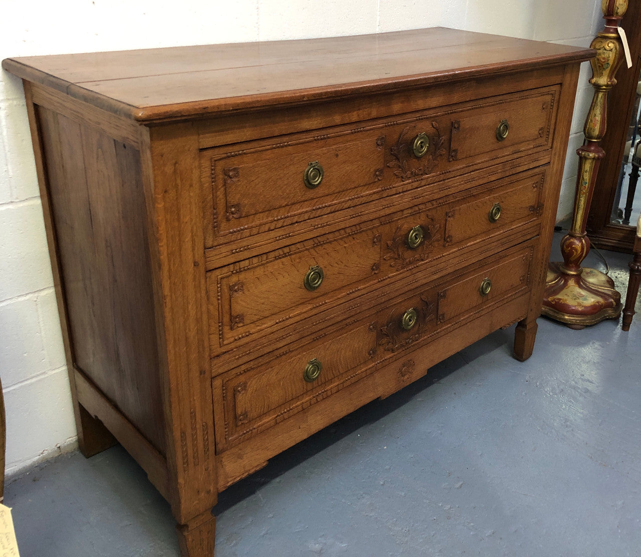 Lovely carved early 19th Century French Oak commode. There are three drawers with decorative drawer pulls and is in good original detailed condition.