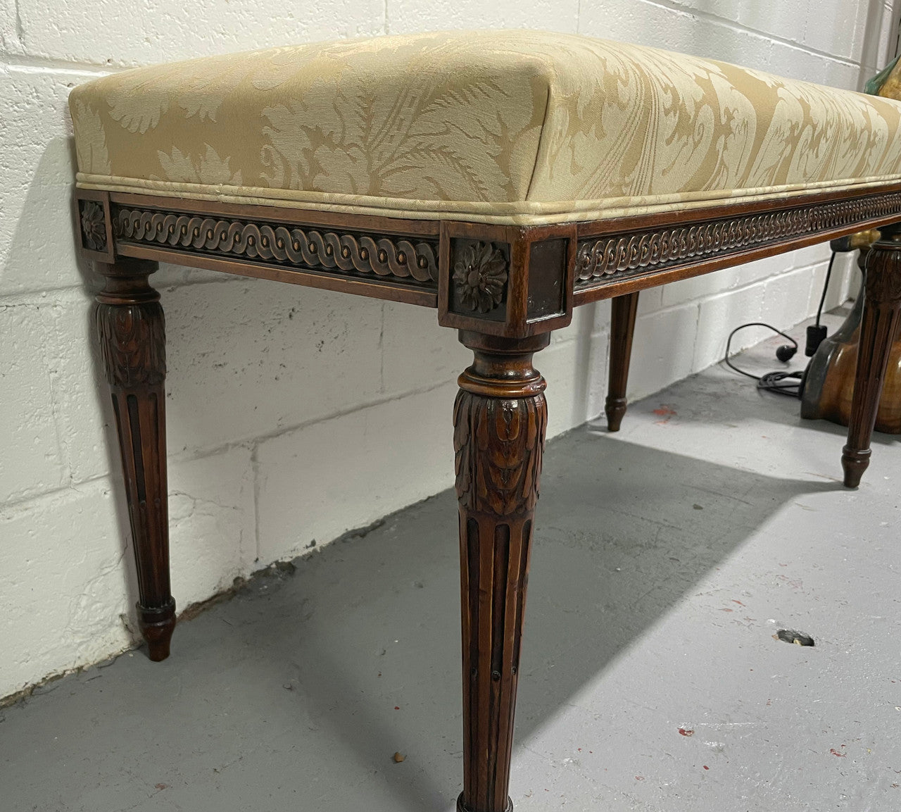 Nicely carved French Louis XVI style Walnut upholstered stool. The stool is in good condition and the frabic is in good used condition, please view photos as they help form part of the description.