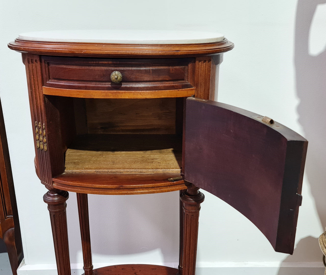 Round Louis XVI style Mahogany marble top side table. It has one drawer and a cupboard for storage. It is in good original detailed condition.