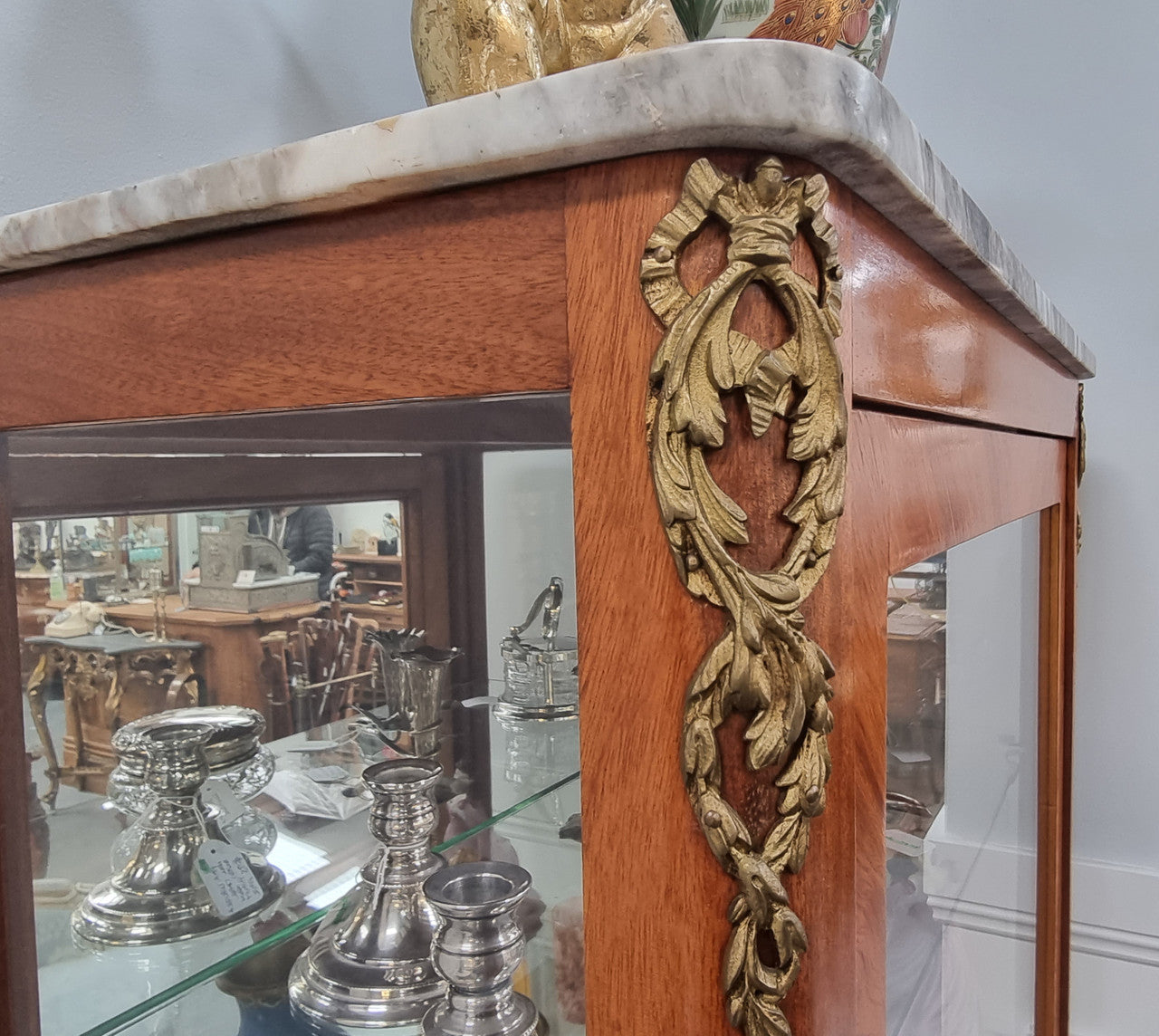 Beautiful French walnut inlaid vitrine with a lovely marquetry design and ormolu mounts. Has a beautiful coloured marble top and two glass shelves. In good original condition.