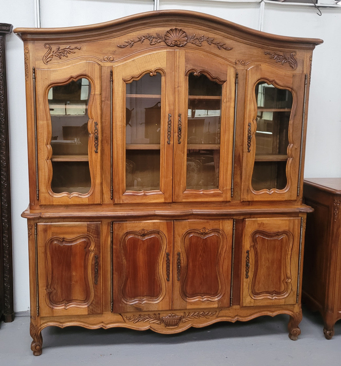 Magnificent French Walnut two-body four door display cabinet. Heaps of storage space with four glass doors at the top with shelves and four solid doors below also with shelving. It has been sourced from France and comes with a key for each door and all are lockable. In good original detailed condition.