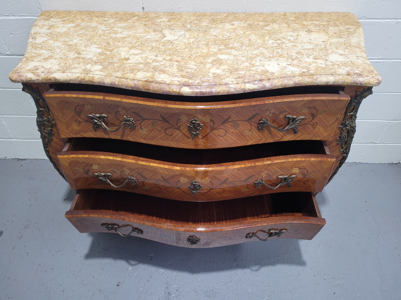 French three drawer marquetry inlaid marble top commode with decorative ormolu mounts. In good original detailed condition.