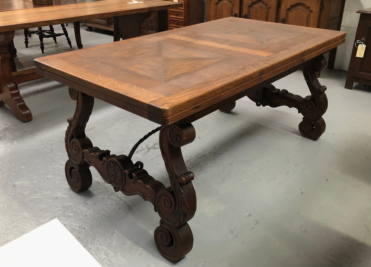 French Oak Renaissance style extension table with a lovely parquetry top and decorative carved and iron base in good original detailed condition.