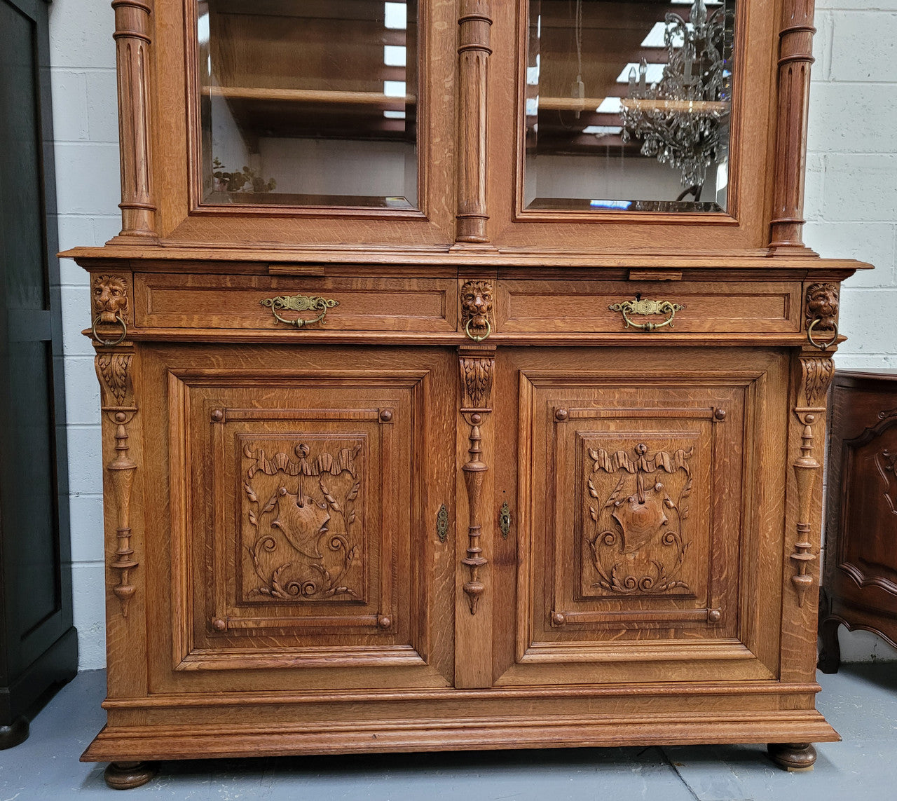 Amazing French 19th Century Oak two-door bookcase. Amazing detailed carvings throughout and plenty of storage space with three adjustable shelves at the top, two drawers, and a further shelf at the bottom. Also has two pull out reading slides giving you a large area to view your books on. In very good original detailed condition.