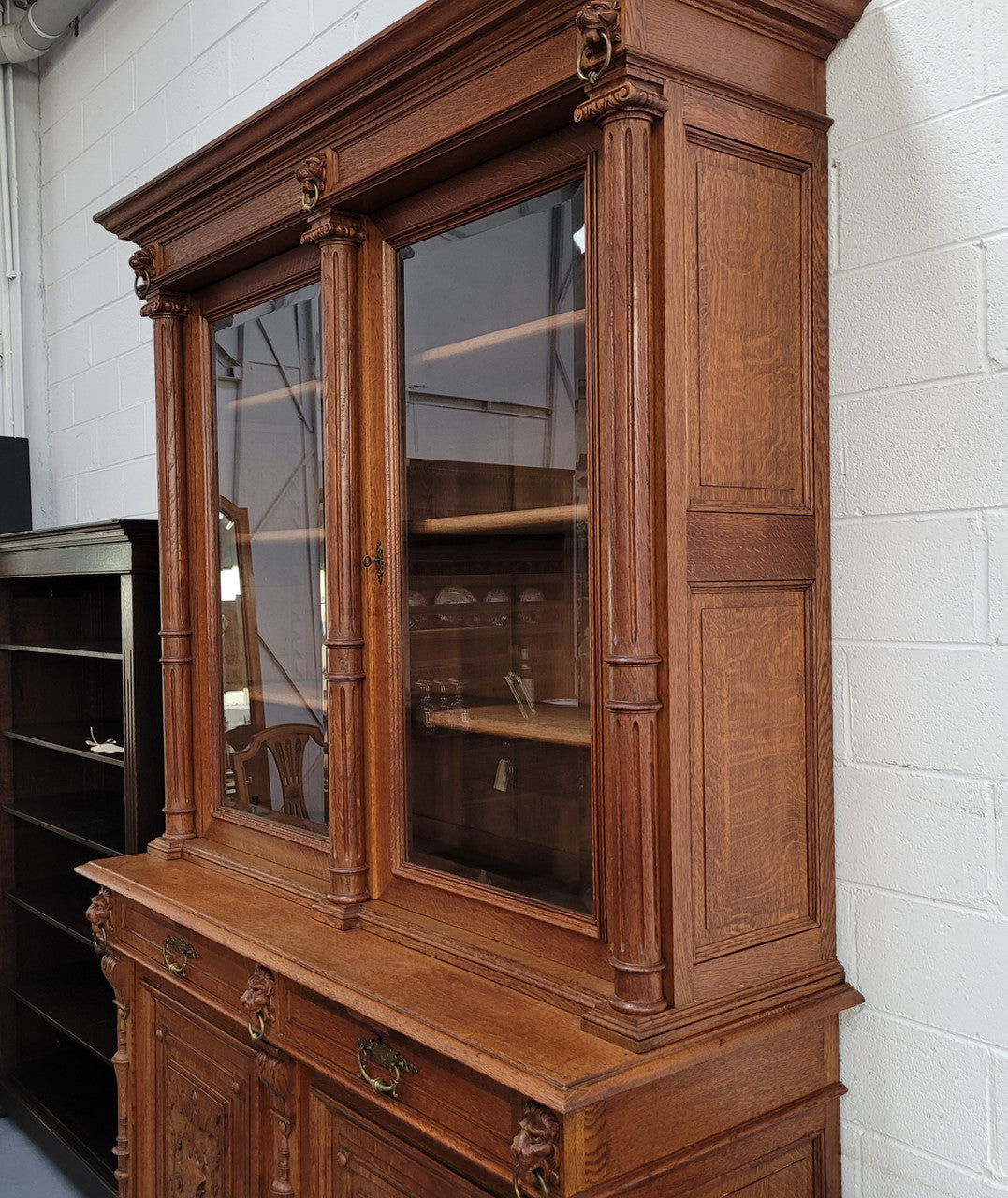 Amazing French 19th Century Oak two-door bookcase. Amazing detailed carvings throughout and plenty of storage space with three adjustable shelves at the top, two drawers, and a further shelf at the bottom. Also has two pull out reading slides giving you a large area to view your books on. In very good original detailed condition.