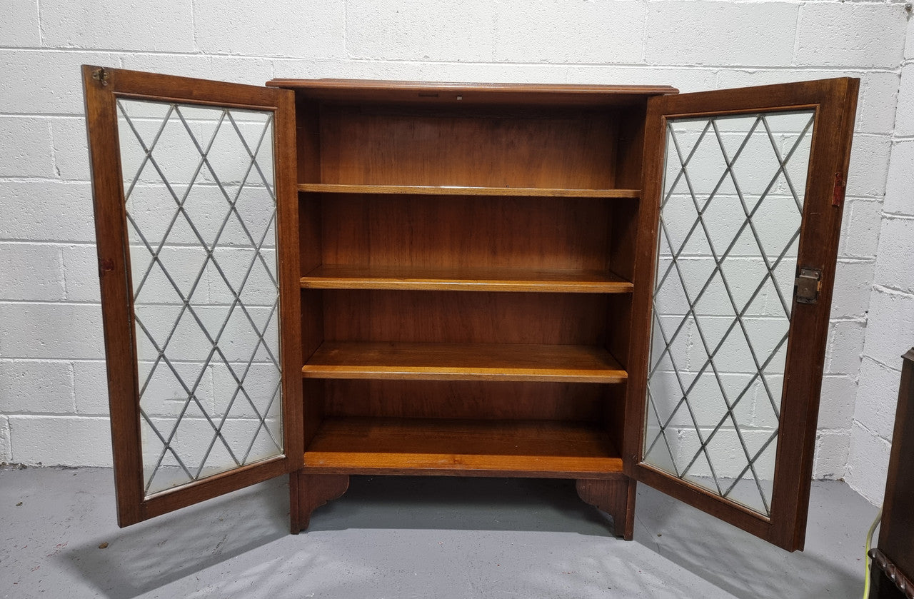 Lovely leadlight two door Oak bookcase/display cabinet with four wooden shelves. It is in good original detailed condition.