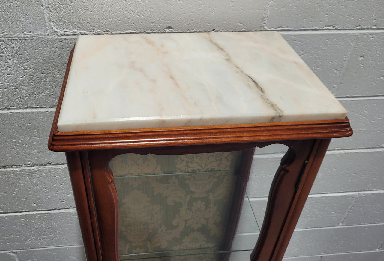 French Louis XV style small scaled display cabinet with marble top. It is of pleasing proportions with a lovely olive french damask fabric back and two glass shelves. In good original detailed condition.