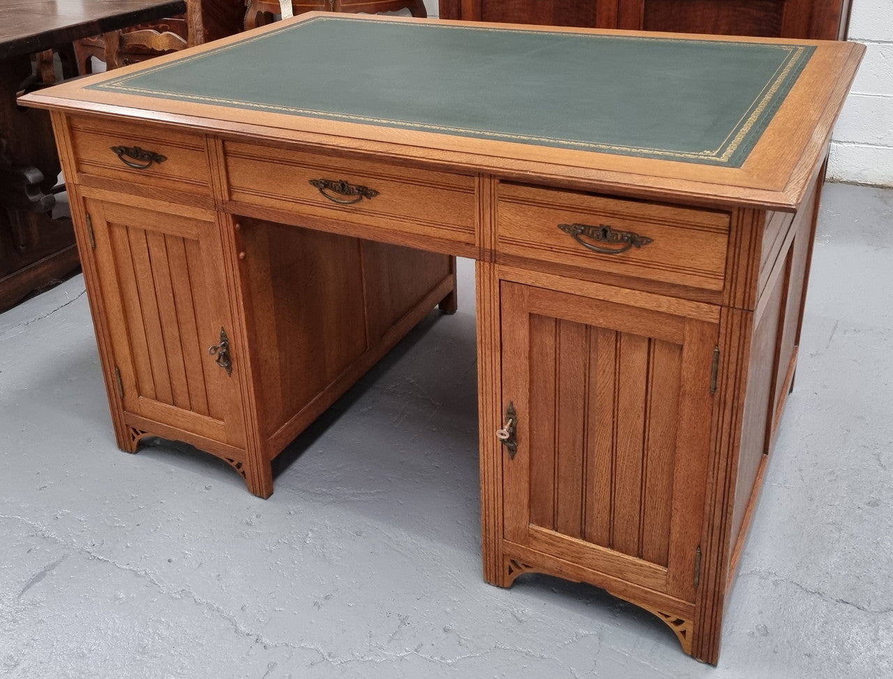 French Oak Art Deco full partners desk with leather top. Plenty of storage with both sides having three drawers at the top and two cupboards on both sides, one side has a filing section with three internal drawers and the other has a shelf on one side with three internal drawers as well. In good original detailed condition.