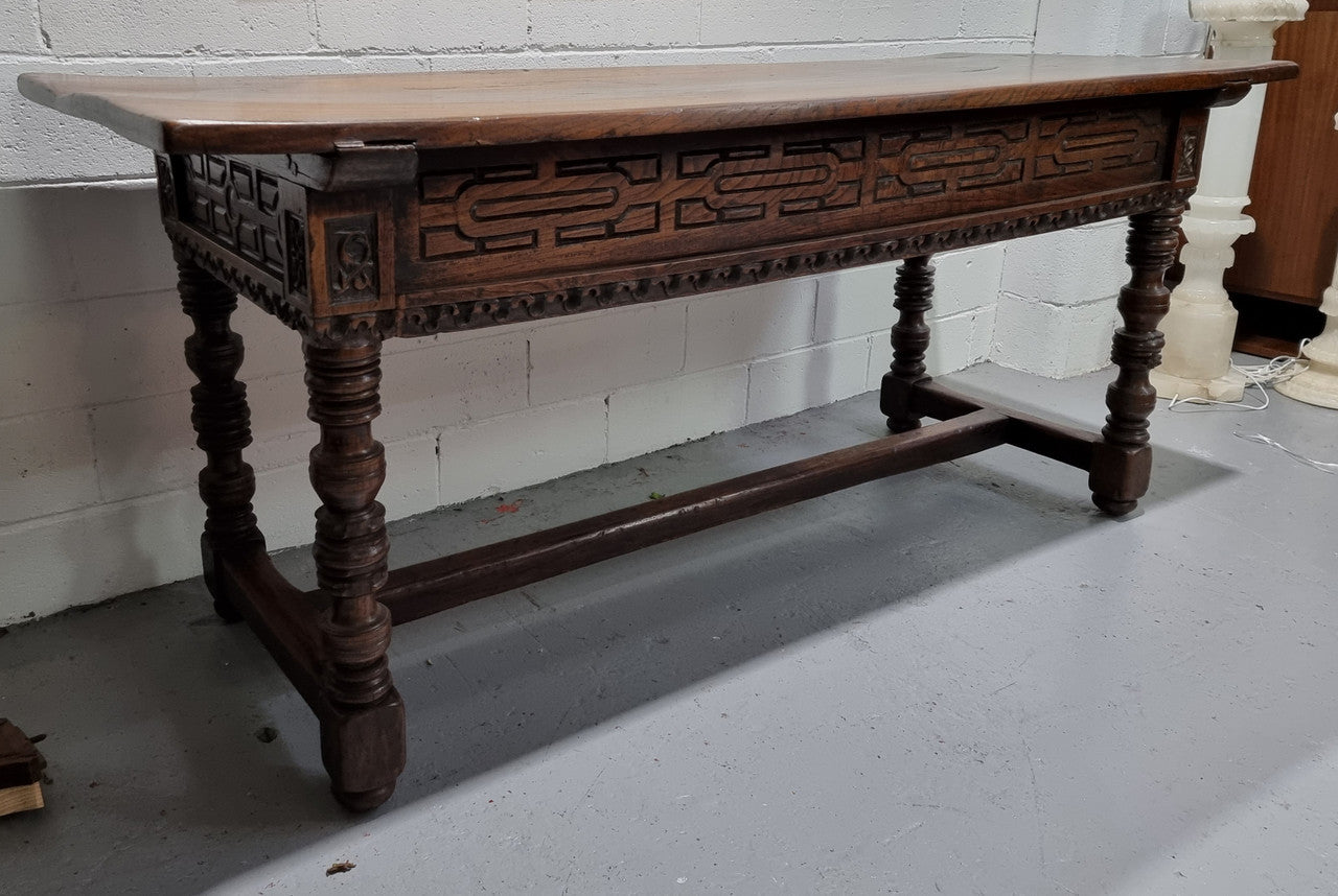 Rare and Charming 17th Century Spanish Walnut serving / side table. It has an incredible one piece walnut top with amazing character and colour. The base displays the original patina aswell as three drawers with carving and remnants of original locks. Superbly turned legs terminating on a stretcher base. Could be used as a large entrance console table, a side table or in a dining area as a serving table. In good original detailed condition especially considering its age.