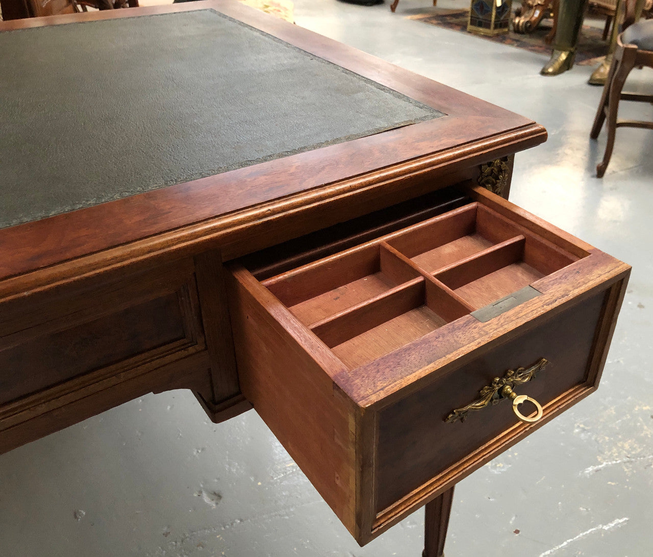 Lovely French Mahogany Louis XVI style leather top desk. With beautiful ormolu details and three drawers. There are also two slides on either side with tooled leather tops and in good original detailed condition.