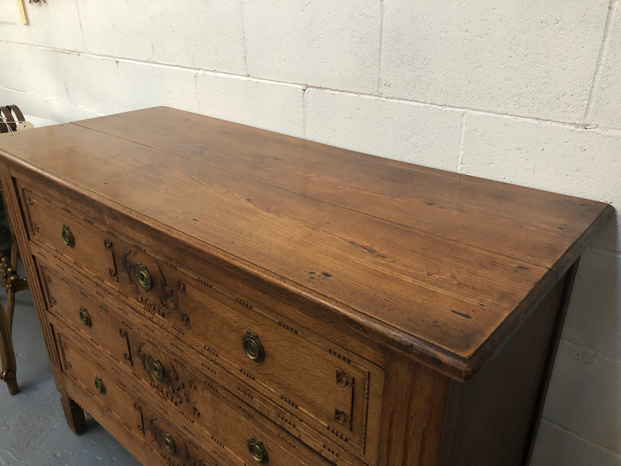 Lovely carved early 19th Century French Oak commode. There are three drawers with decorative drawer pulls and is in good original detailed condition.