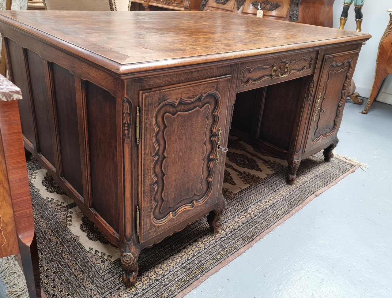 Fabulous Louis XV style French Oak beautifully carved full partners desk. Both sides have a functioning drawer in the middle and two cupboards either side. On both sides one cupboard door opens up to four smaller internal drawers. Plenty of storage space and a large top surface to work on. It is in good original detailed condition.