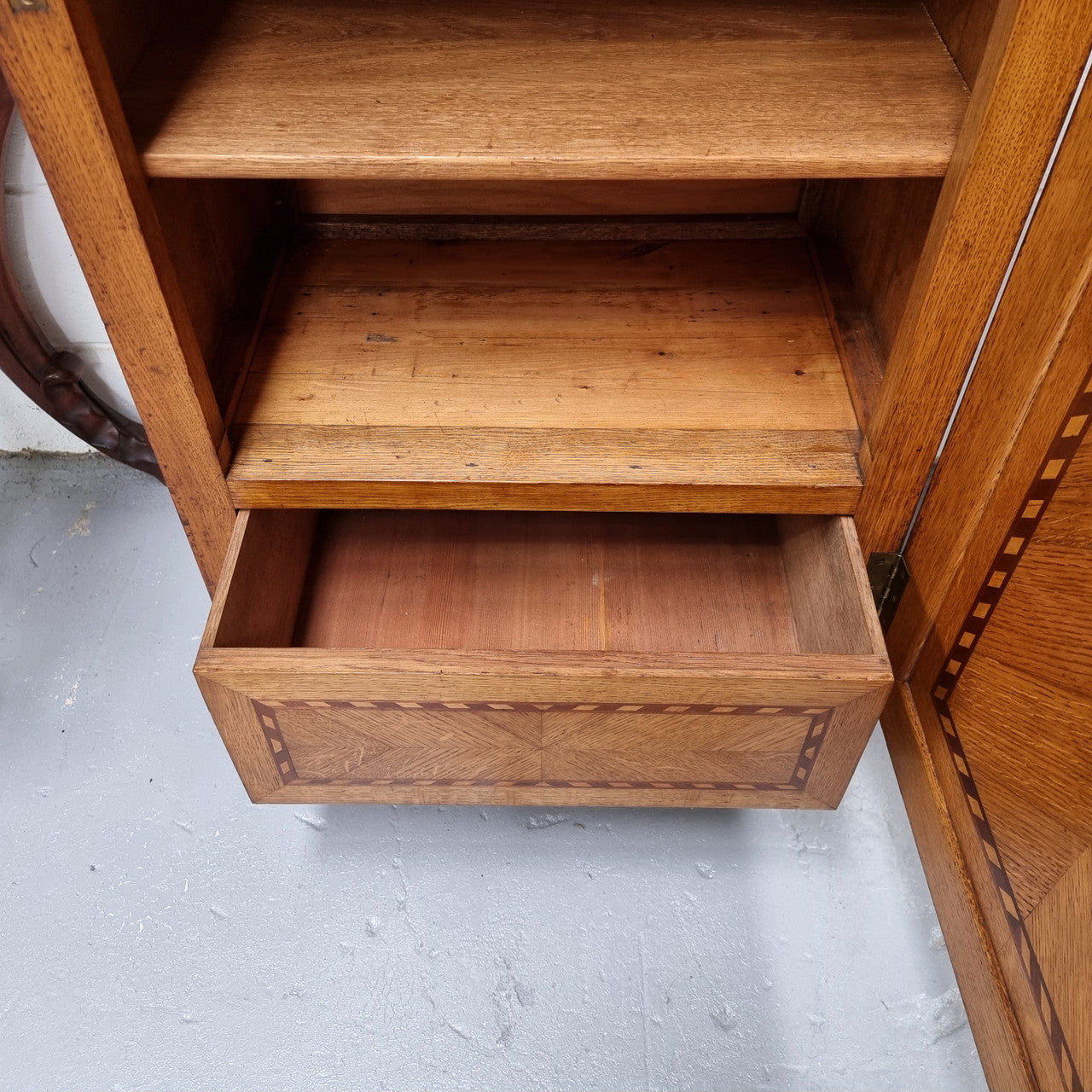 French Art Deco inlaid Oak curio/side cabinet with a lift up top and glass underneath. There are two fixed shelves, two adjustable shelves and one hidden drawer. Sourced from France and in good original condition.