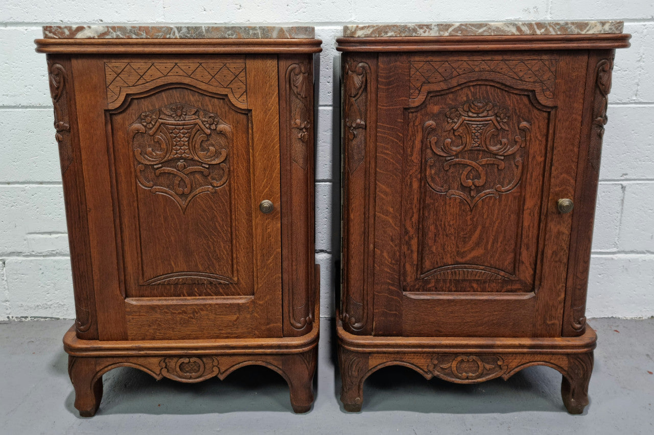 Lovely pair of French oak bedside cabinets with nicely carved details and marble tops. In good original detailed condition.